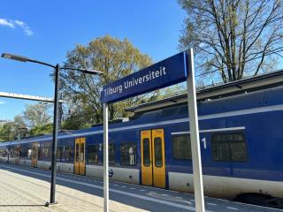 Station Tilburg Universiteit met bord en trein