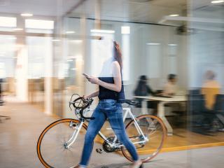 werknemer met fiets in kantoor