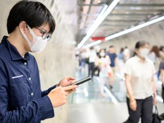 man with facemask using mobile phone 
