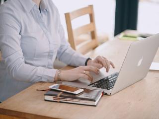 Thuiswerkende vrouw aan tafel met laptop